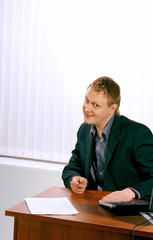 The businessman sitting at a table with a computer