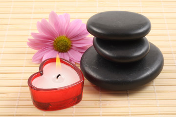 stack of pebbles with candles and flower - aromatherapy