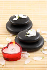 stack of pebbles with candles and flower - aromatherapy