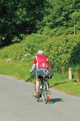 A group of senior cyclists cycling along road warwickshire