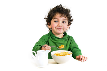 young boy eating cornflakes isolated on white