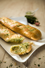 two loafs of french baguette filled with butter with herbs