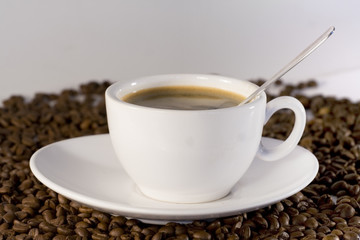 Cup of coffee view from above and coffee beans background