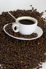 Cup of coffee view from above and coffee beans background