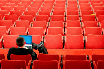 Homme seul avec un portable assis dans une salle