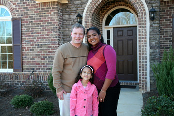 A family standing in front of their home