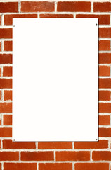 Blank white sign on a colorful brick wall.