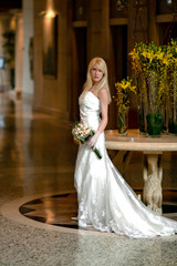young woman in a wedding dress standing in hall