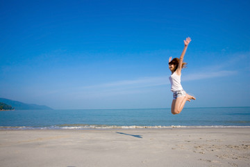 Fototapeta na wymiar woman jumping happily by the beach