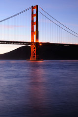 Southern tower of Golden Gate Bridge glows at sunset 