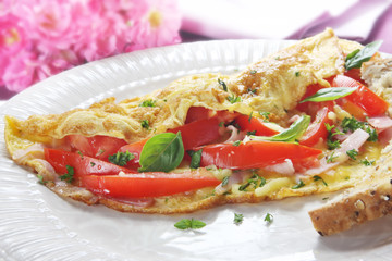 Omelette with tomato, ham, cheese, and basil