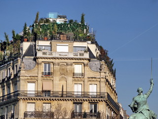 Statue devant immeuble de pierre avec terrasses, Paris