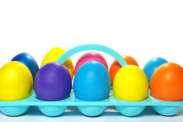 Easter holiday. Color eggs in a tray on white  background.