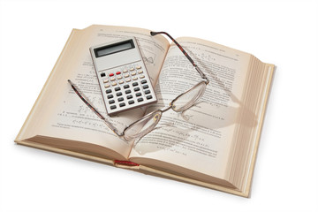 calculator and glasses on opening textbook