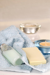 Obraz na płótnie Canvas Świeże niebieskie ręczniki z szamponu, mydła i świec