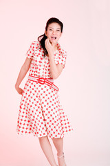 girl in a red dress with white dots with an expressive face 