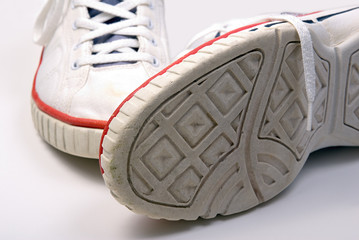 an old pair of running training jogging shoes on white