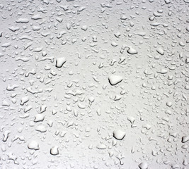 Rain droplets on a grey metallic surface