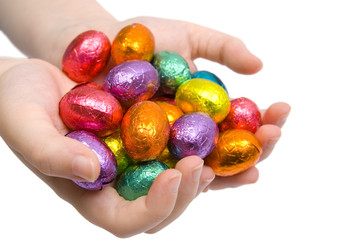 A child holding out a handful of colourful Easter Eggs