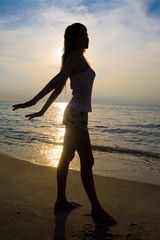 Fototapeta premium silhoette of a woman doing stretching exercise at sunset