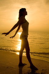 golden silhoette of a woman doing yoga exercise at sunset
