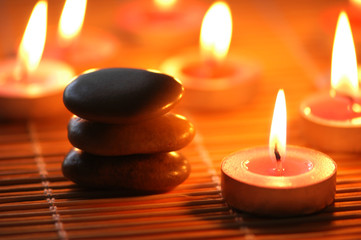 Obraz na płótnie Canvas Kamyki i płonące świece dla aromaterapii sesji