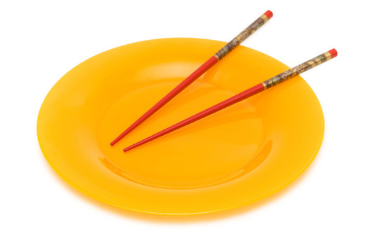 Yellow plate and chopsticks isolated on white