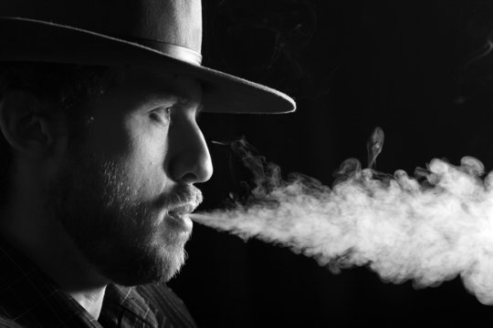 An image of a smoking man on dark background