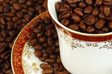 Cup full of coffee beans with a plate