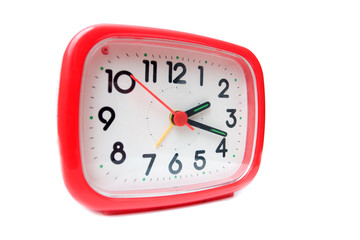 Old red alarm clock on a white background