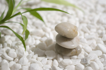 zen stones and bamboo on white pebbles background 