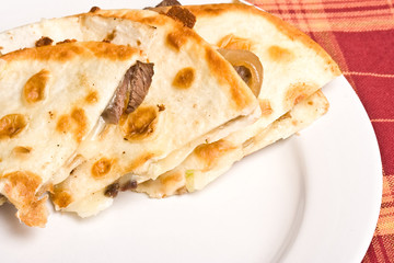fresh off the stove a steak Quesadilla on a white plate