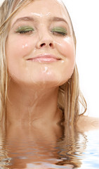 Naklejka premium portrait of happy blond washing face in water