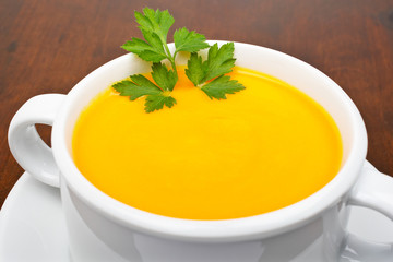 Carrots puree with parsley on wooden background. Shallow DOF