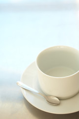 Obraz na płótnie Canvas Empty white ceramic coffee cup and silver teaspoon 
