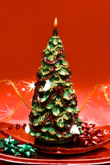 Christmas tree candle on red background