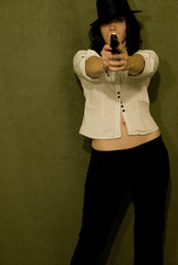 Gorgeous female model posing with a gun in a studio.