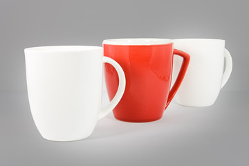 Set of three coffee mugs on graduated gray background