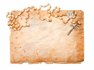Rosary with cross over the old parchment.