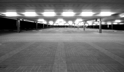 an empty spacious parking lot by night in black and white