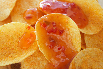 Crispy golden brown potato chips with a hot salsa dip sauce