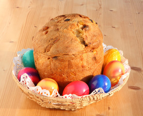 Easter eggs and bun on a wooden table.