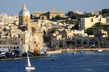 Fototapeta na wymiar vista della costa maltese con barca a vela bianca 2