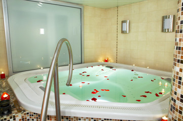 Bath of a jacuzzi with petals of roses.