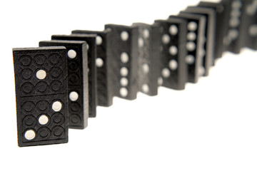 Dominoes standing in a row over white