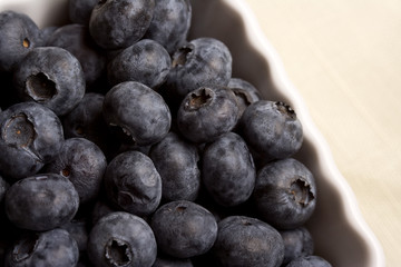 a white cup full of fresh ripe blueberries