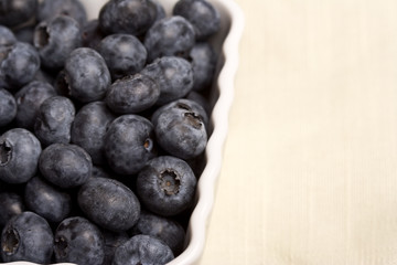 a white cup full of fresh ripe blueberries