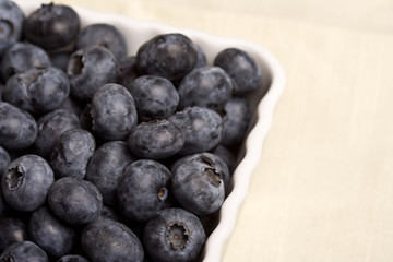 a white cup full of fresh ripe blueberries