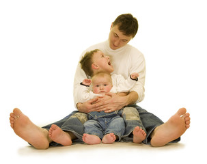 Father and sons barefoot on the floor.