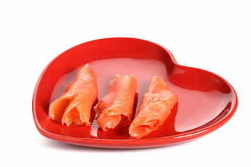 three pieces of smoked salmon on red heart shape plate